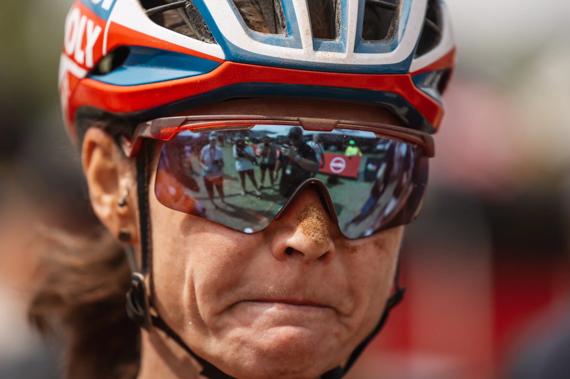 A rider's portrait, mud-covered face, intense