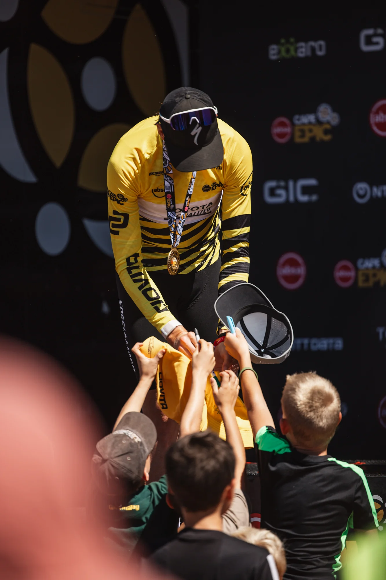 Riders celebrating, yellow leader's jersey held up