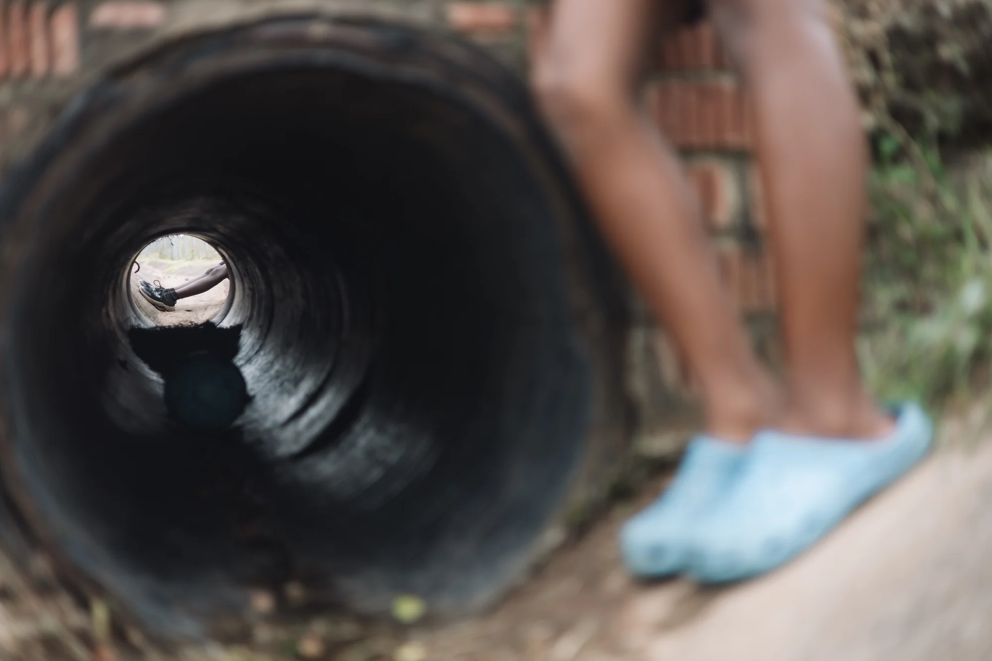 A child playing inside a tunnel, black and white