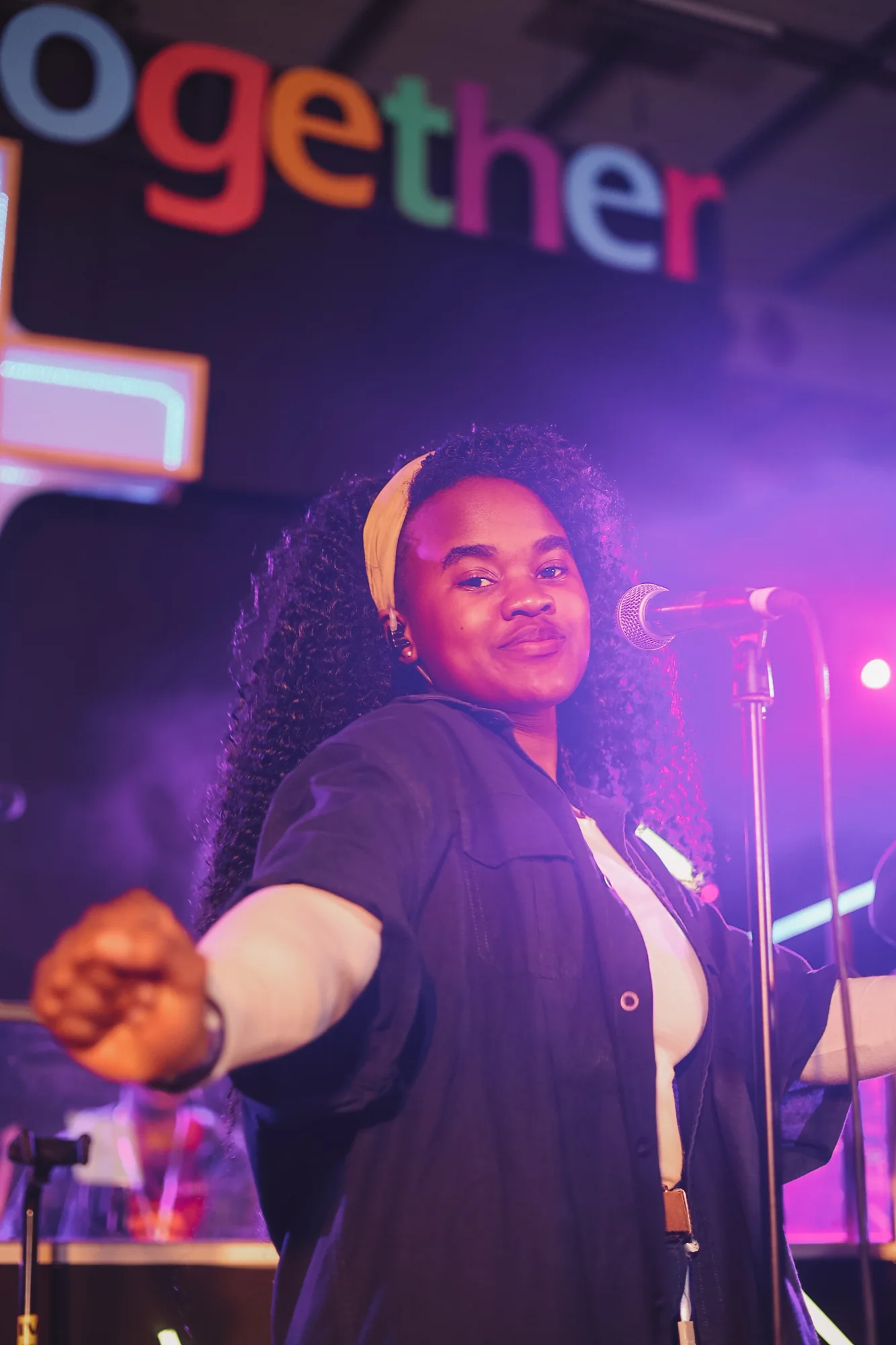 A woman singing on stage, purple lighting