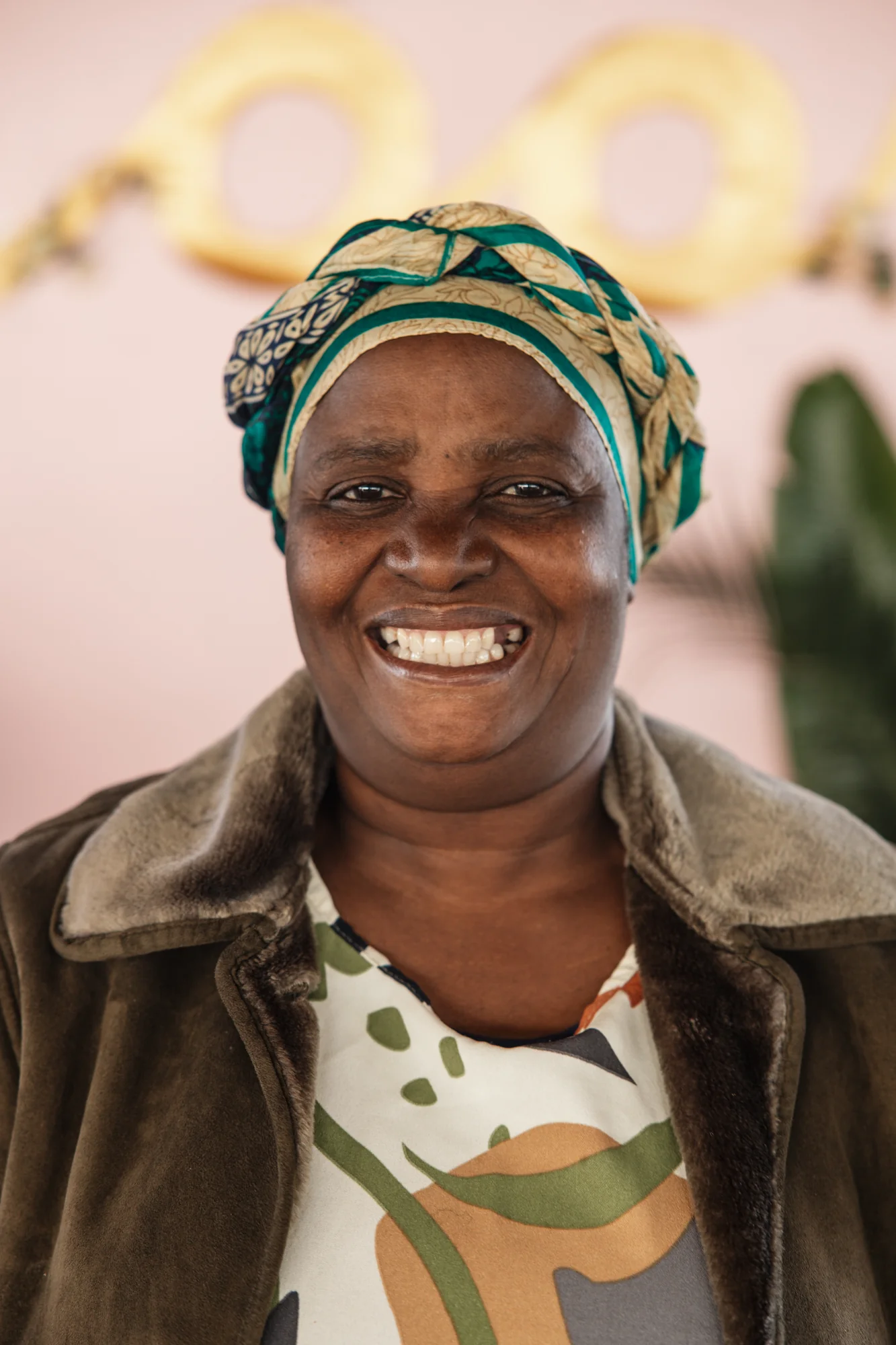 A woman's portrait, headwrap, warm smile