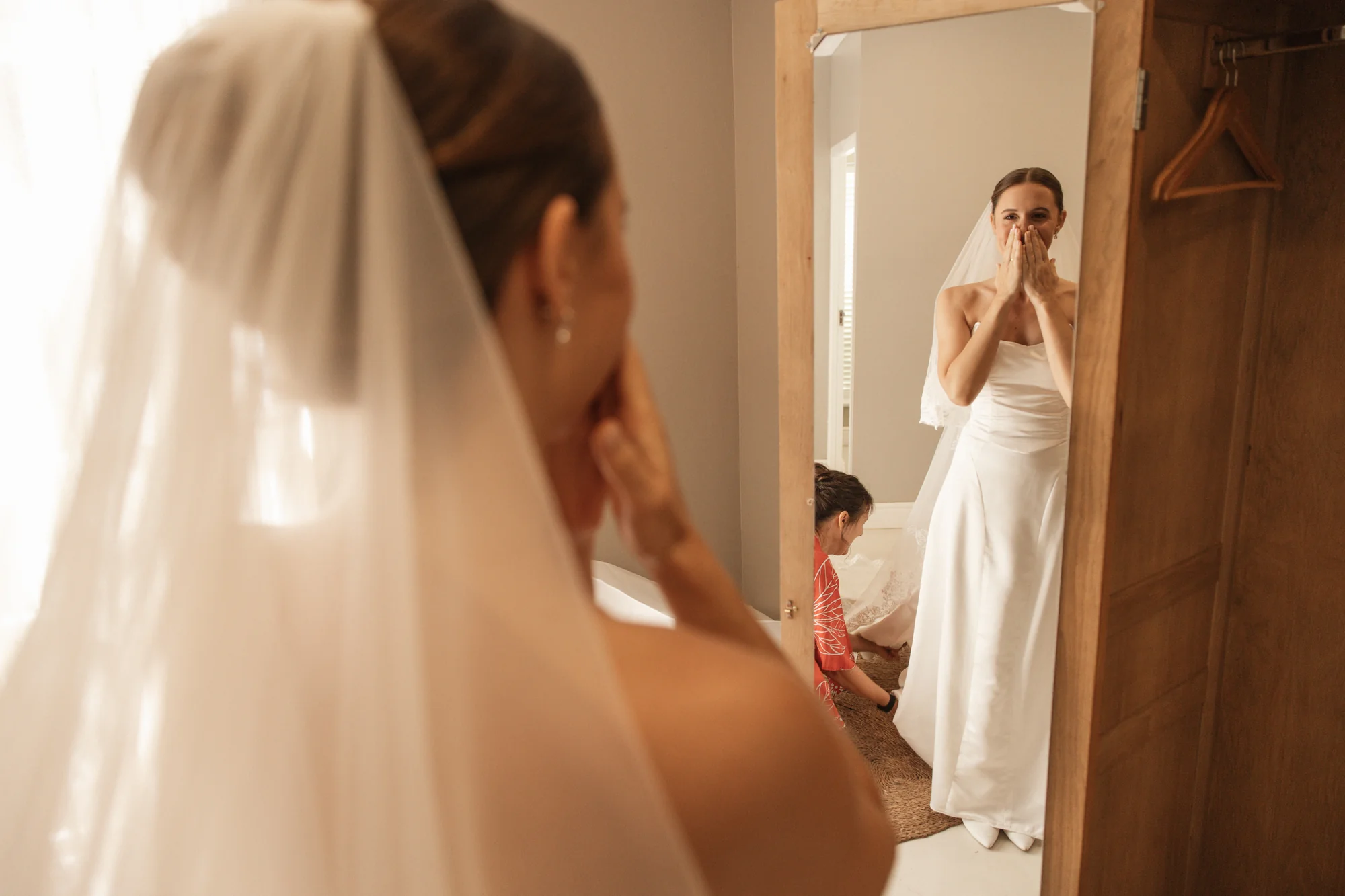The bride being zipped into her dress