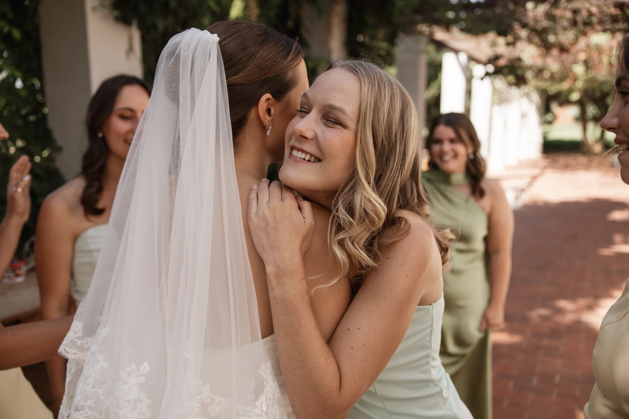 The bride laughing with a bridesmaid, close
