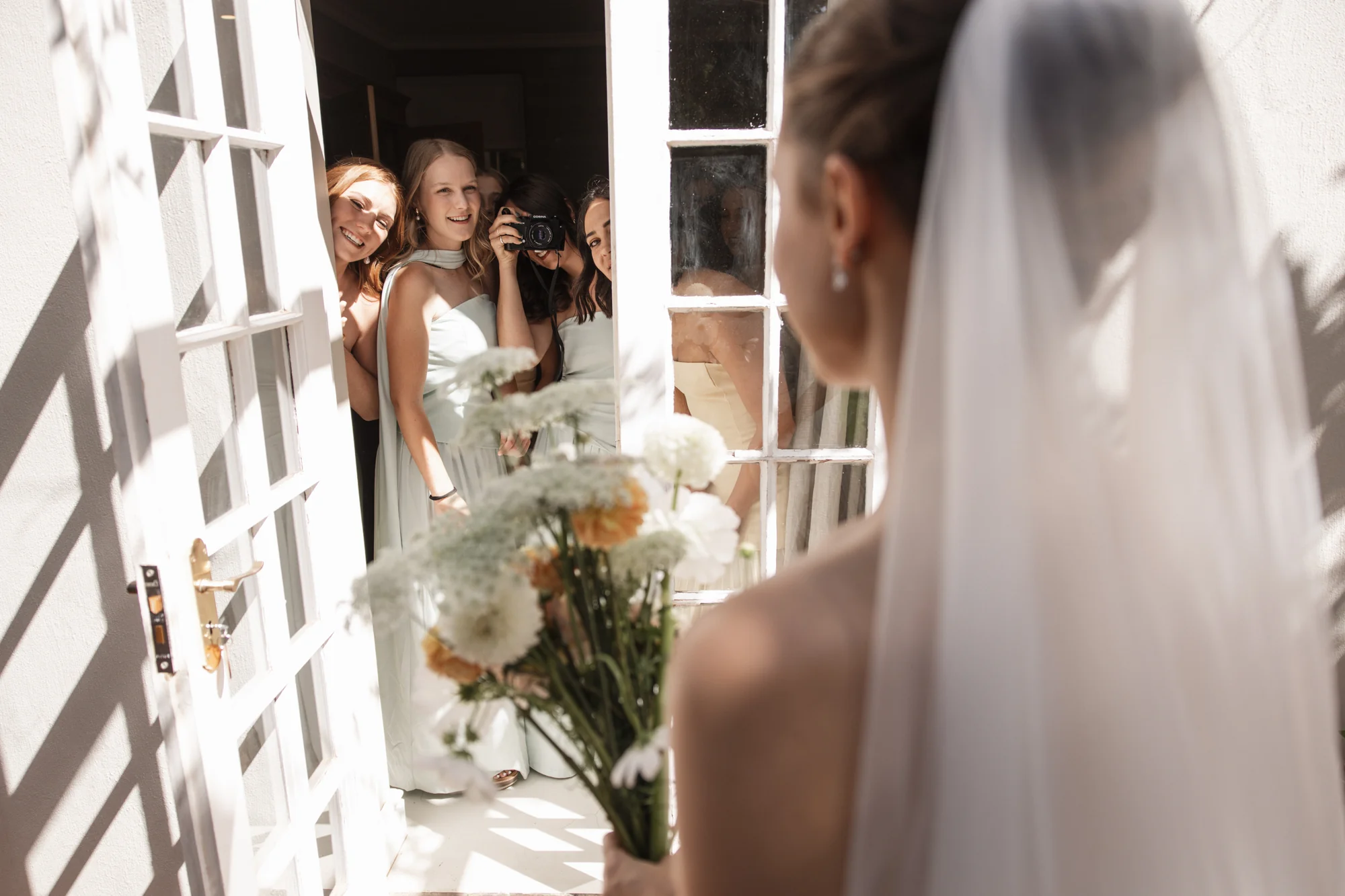 The bride walking through a doorway, veil in motion