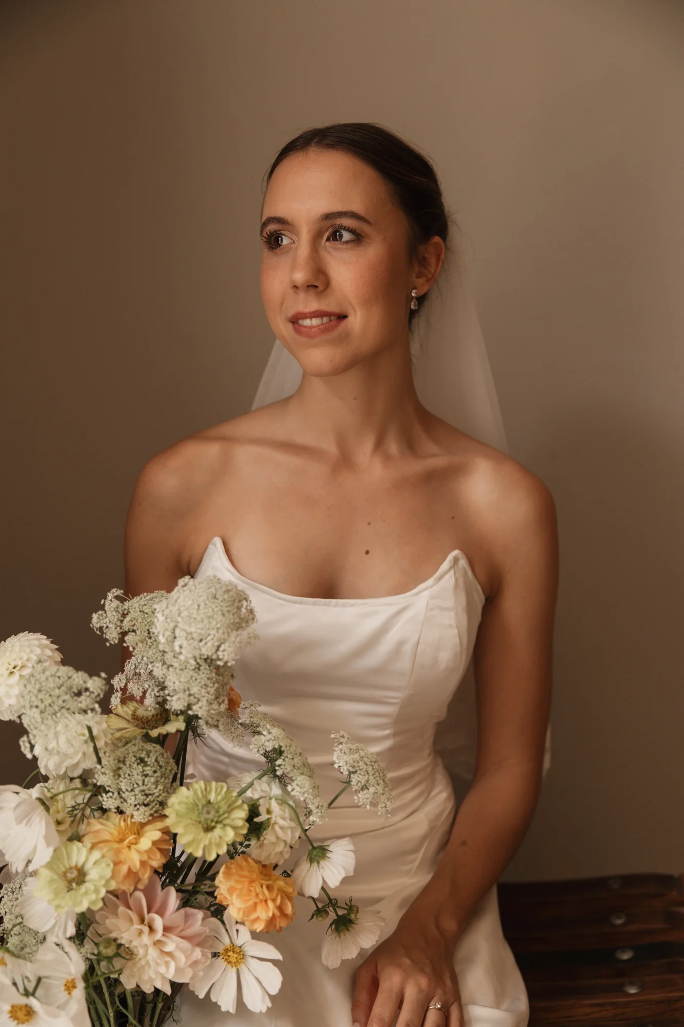 A portrait of the bride indoors, with the bouquet