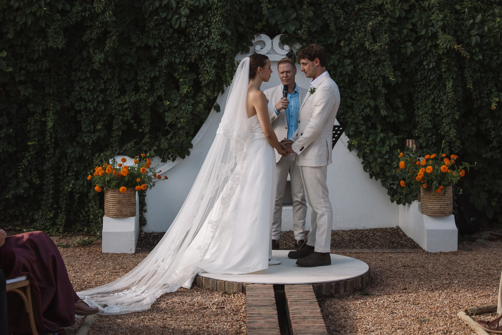 The kiss, beneath the floral arch
